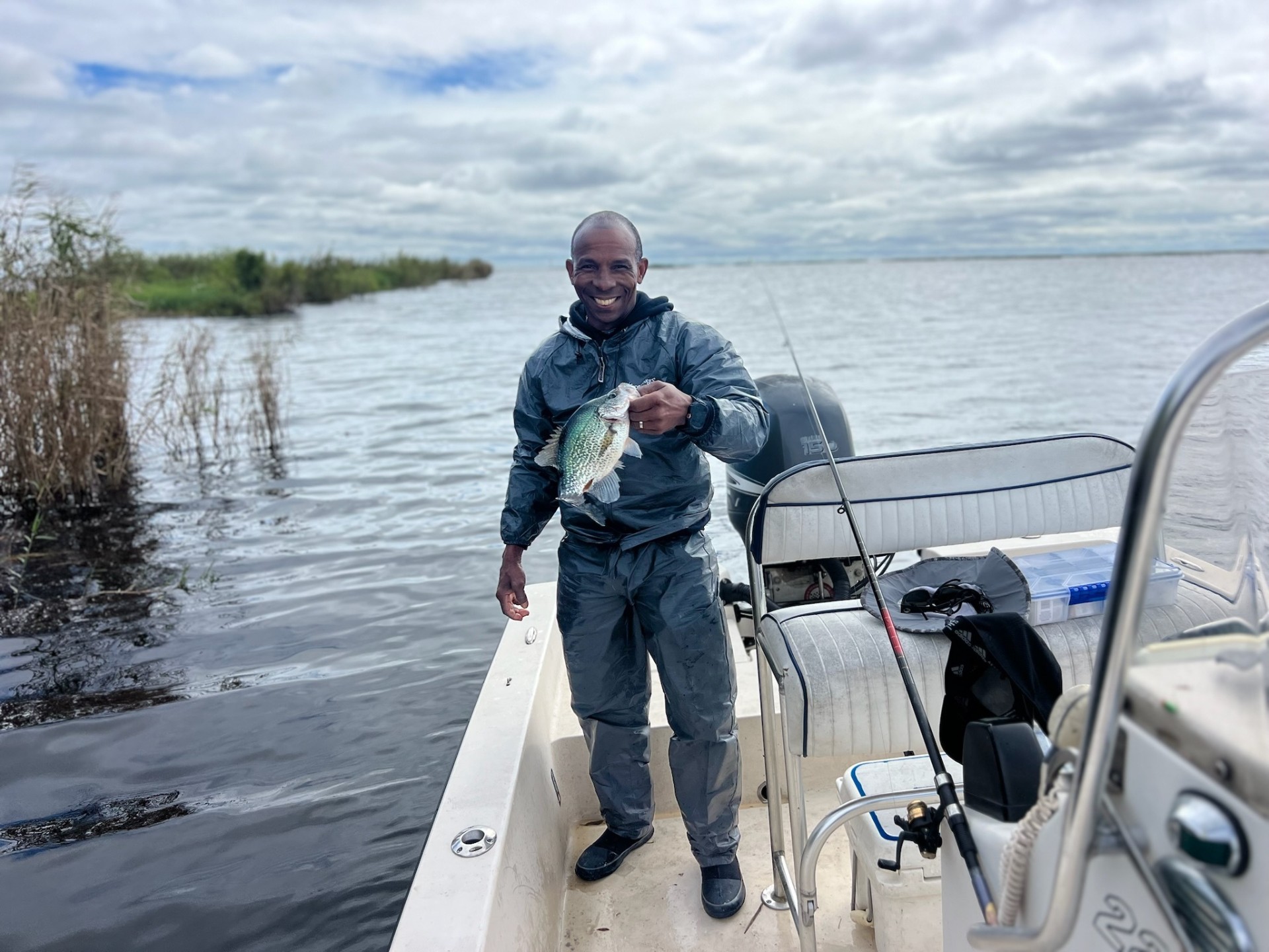 Fisherman holding a crappie catch on a cloudy day