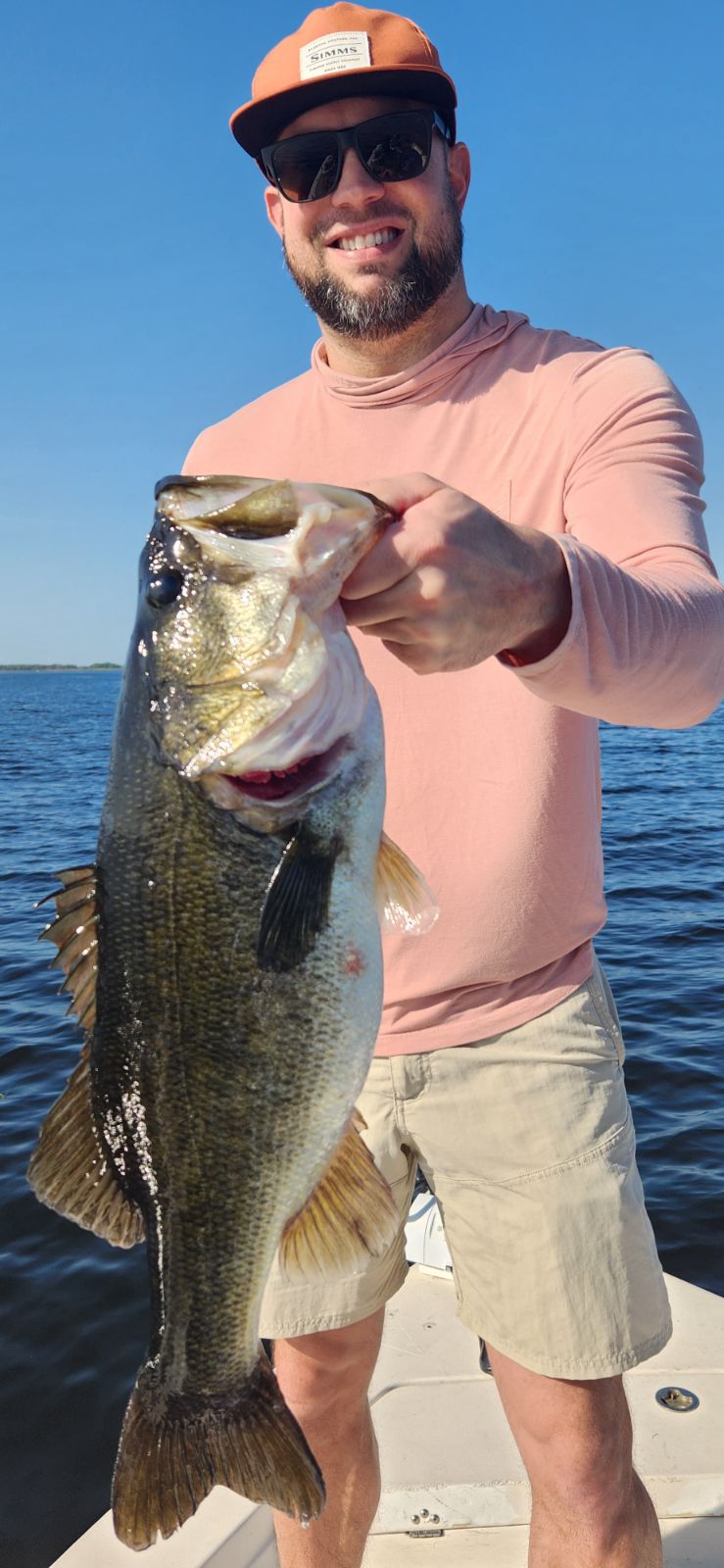 Angler holding a huge largemouth bass in the Florida sun