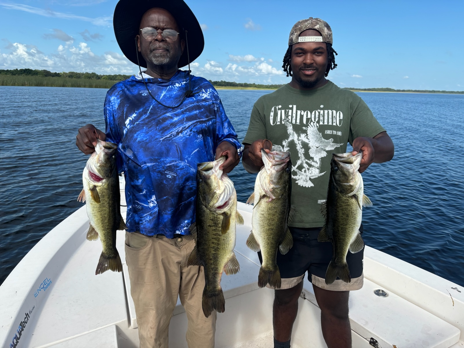 Father and son with a haul of bass on the boat