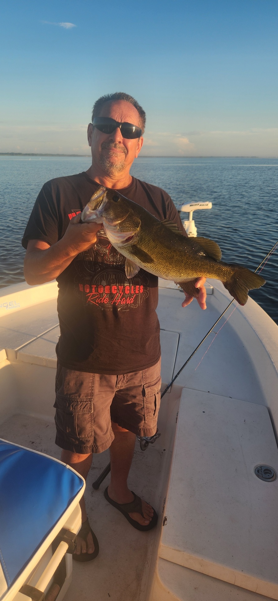 Fisherman with a nice bass catch at sunset